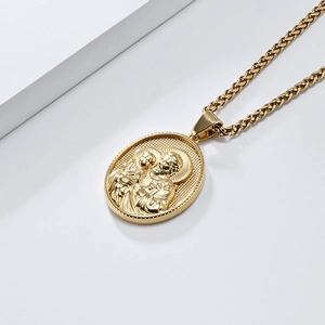 Vue détaillée du collier doré avec pendentif en relief religieux sur fond blanc