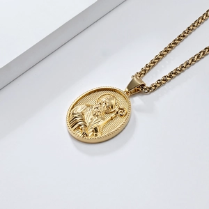 Vue macro d'un pendentif ovale doré avec portrait de saint sur chaîne en acier