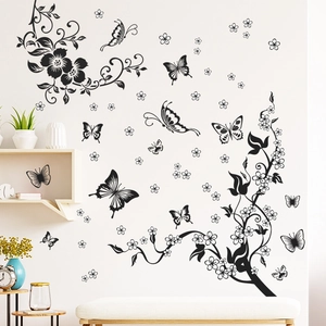 Detail of black floral and butterfly wall stickers on a neutral interior bedroom wall