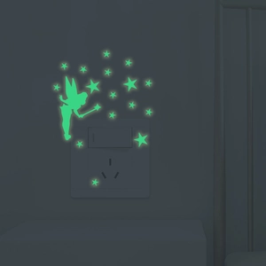 Luminous fairy and stars wall stickers glowing in the dark around a light switch