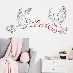 Modern wall sticker with black flying doves and red Love text in a cozy living room