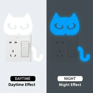 Glow-in-the-dark cat wall sticker showing blue luminous effect and daytime white view