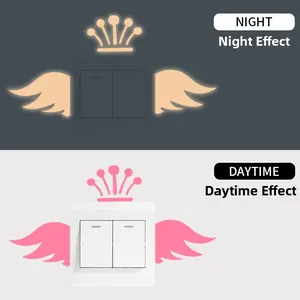 Luminous wall stickers on dual-switch panel showing daytime and night effect with crown and wings