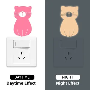 Luminous pink cat switch sticker showing day and night glow effects for home wall decor