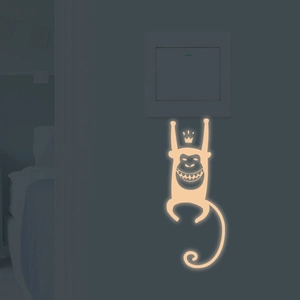 Luminous cartoon crown monkey light switch wall sticker showing warm yellow glow in dark