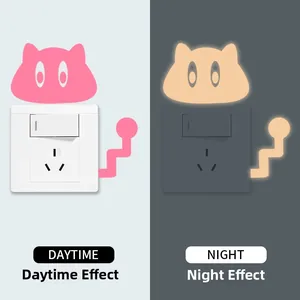 Glow in the dark cat light switch sticker showing daytime vs night luminescence effect