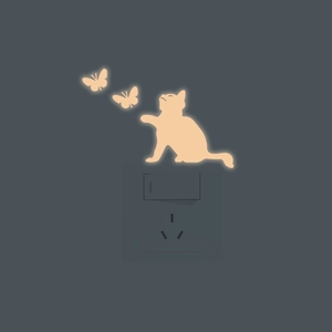 Luminous cat and butterfly light switch stickers with warm orange glow effect