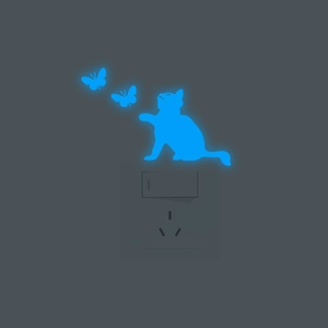 Luminous cat and butterfly wall stickers glowing in blue near a light switch