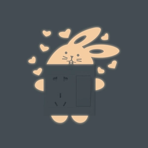 Luminous bunny and heart wall decal surrounding a grey electrical switch socket