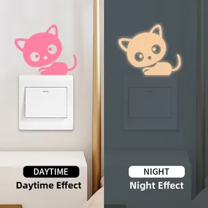 Luminous cat light switch sticker showing day and night glow effect in pink and orange