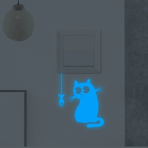 Adesivo murale fluorescente blu con gatto e pesci su un interruttore nel buio totale