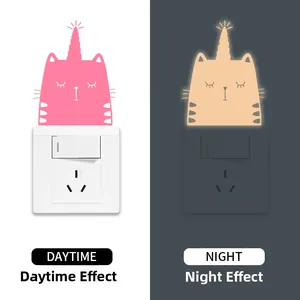 Autocollant interrupteur chat licorne montrant le rose de jour et la lueur chaude de nuit