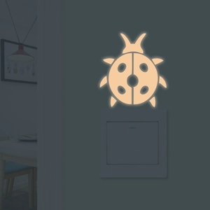 Adesivo murale coccinella luminosa arancione caldo su interruttore luce bianco