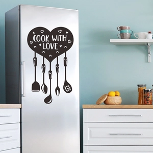 Detail showing Cook With Love wall decal with heart and kitchen utensil icons on fridge
