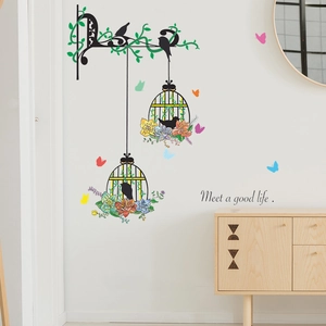 Detail of birdcage wall sticker with colorful flowers and butterflies on white wall