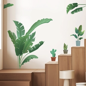 Detail view of tropical green leaf and potted plant wall stickers on a white interior wall
