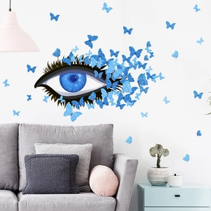 Artistic blue eye and butterfly wall decals displayed on a minimalist living room wall