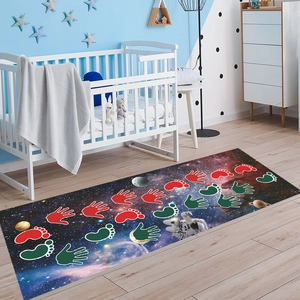 Detail view of starry universe themed nursery rug with astronaut and colorful handprint design