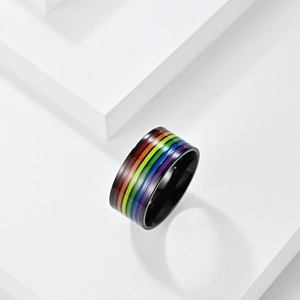 Anello largo nero in acciaio inossidabile con strisce arcobaleno su podio bianco