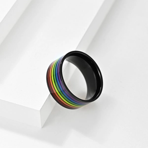 Vista macro laterale dell'anello arcobaleno LGBTQ+ con bordi neri su un piedistallo bianco