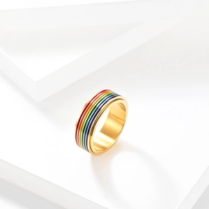 Vista detallada de un anillo giratorio de acero dorado con vibrantes rayas de esmalte