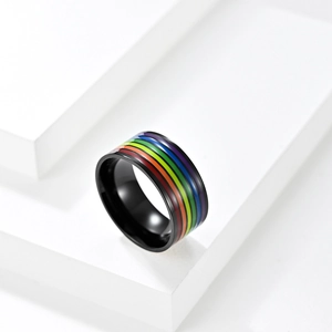 Dettaglio dell'anello in acciaio nero con strisce arcobaleno su un blocco bianco