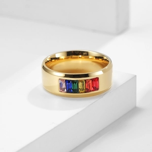 Dettaglio ravvicinato dell'anello con gemme arcobaleno su un display bianco minimalista