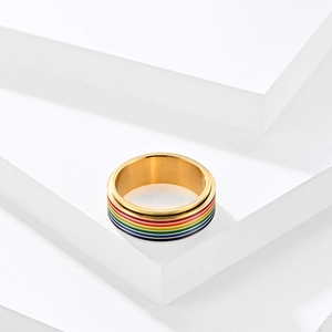 Detalle de un anillo giratorio arcoíris dorado sobre bloques geométricos blancos