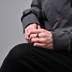 Primer plano de un anillo ancho de acero inoxidable pulido en el dedo para un estilo minimalista