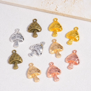 DIY mushroom pendants set in gold, silver, and bronze finishes for jewelry making