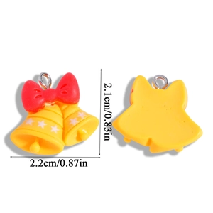 Detail of yellow Christmas bell charms with red bows and white stars for DIY jewelry