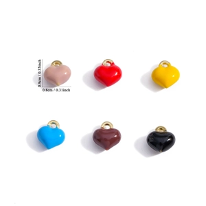 Macro view of colorful enamel heart charms in six vibrant colors with gold loops for DIY