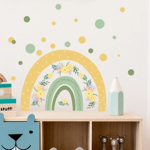 Detail view of rainbow flower wall stickers in soft yellow and green on white wall