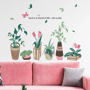 Detail view of floral potted plant wall stickers and quote above a pink sofa