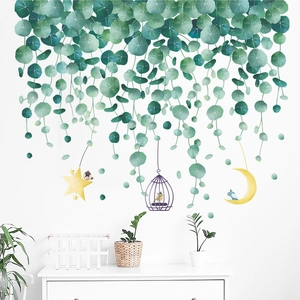 Detail of tropical green leaf wall stickers with a purple birdcage and crescent moon
