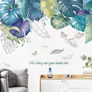 Detail of tropical monstera leaves wall stickers with elegant cursive quote in modern living room