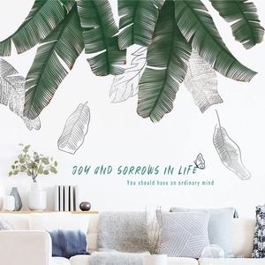 Detail of tropical banana leaf wall stickers with inspirational text on a white wall