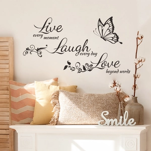 Detail view of black inspirational quotes wall decals with butterfly in cozy living room decor