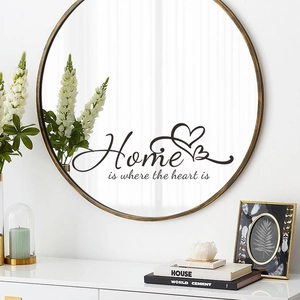Detail of Home is where the heart is wall decal applied on a round mirror surface