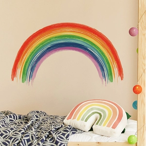 Pastel rainbow wall stickers and matching pillows in a cozy bedroom scene