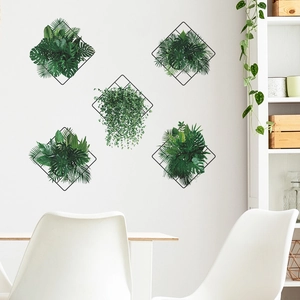 Modern wall decor featuring black iron grids and tropical faux greenery on a white wall