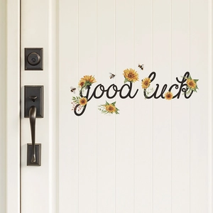 Detail of Good Luck wall sticker with yellow sunflowers and bees on white door