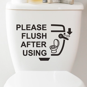 Gros plan d'un autocollant noir Please Flush After Using sur un WC en céramique blanche