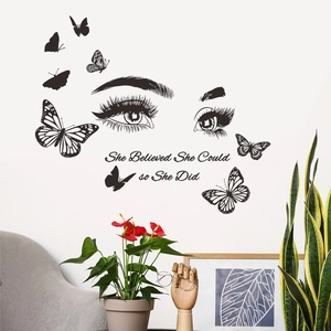Detail of She Believed She Could wall decal with butterflies above a living room sofa