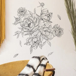 Detail of minimalist black sketch peony wall decals applied in a cozy living room scene
