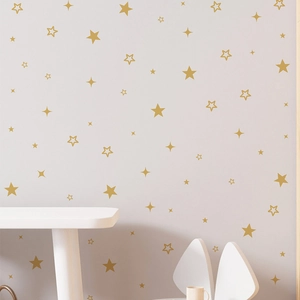 Detailed view of matte gold star wall stickers in a cozy pink modern nursery room