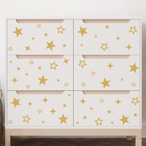 Minimalist white six-drawer dresser with decorative gold star stickers and wooden legs