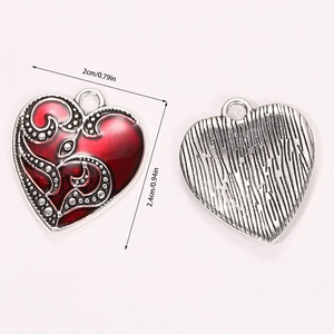 Macro view of vintage heart charm showing red enamel front and brushed silver back