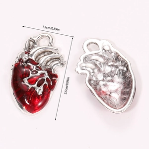 Macro view of anatomical heart charms with red enamel and silver metal finish