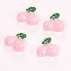 Macro shot of 4 translucent pink resin cherry charms with green leaves for DIY jewelry making